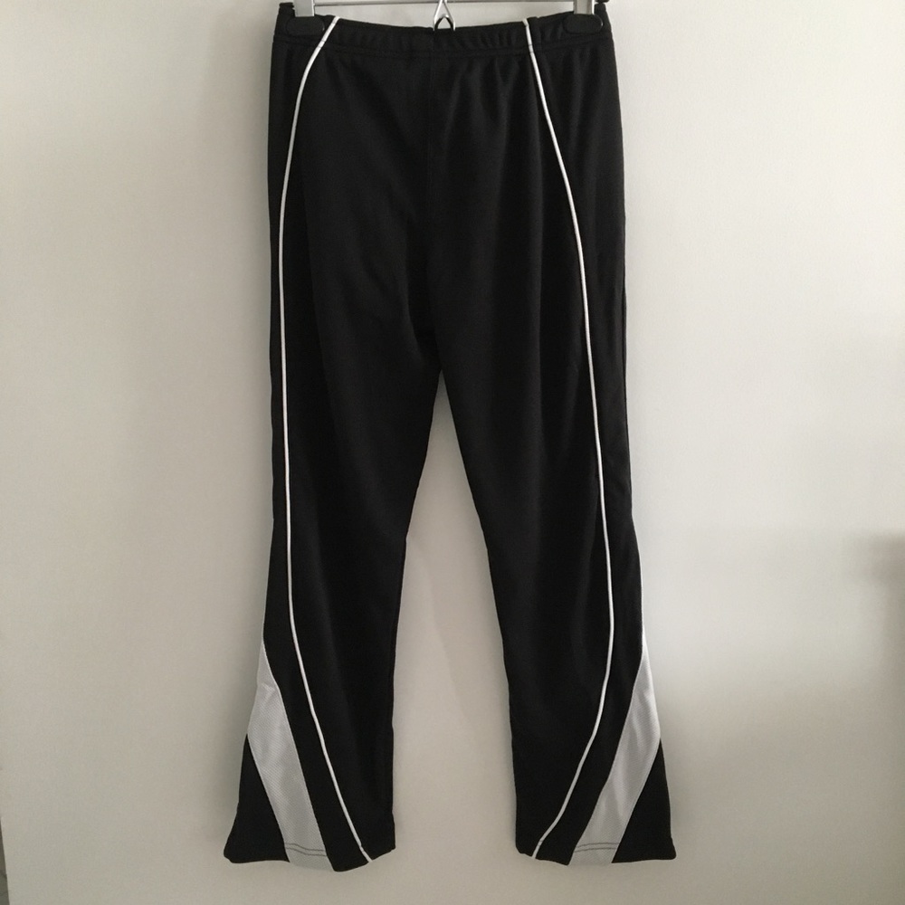Black Nike athletic pants with striped sides. zip up ankles